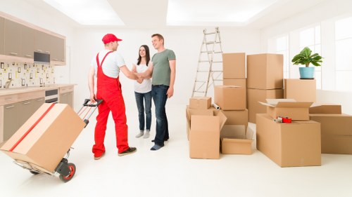 Local movers carefully packing household belongings in a Bermondsey flat