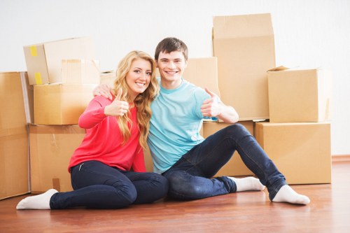 Professional movers carrying boxes into a Bermondsey apartment building